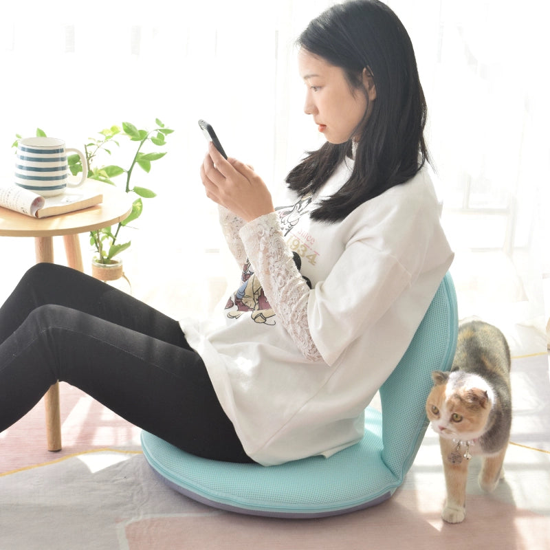 A girl is seated on the ZenFlex Chair, casually looking at her phone. 